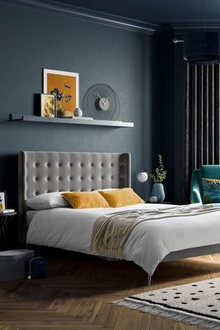dark blue moody bedroom with yellow decor 