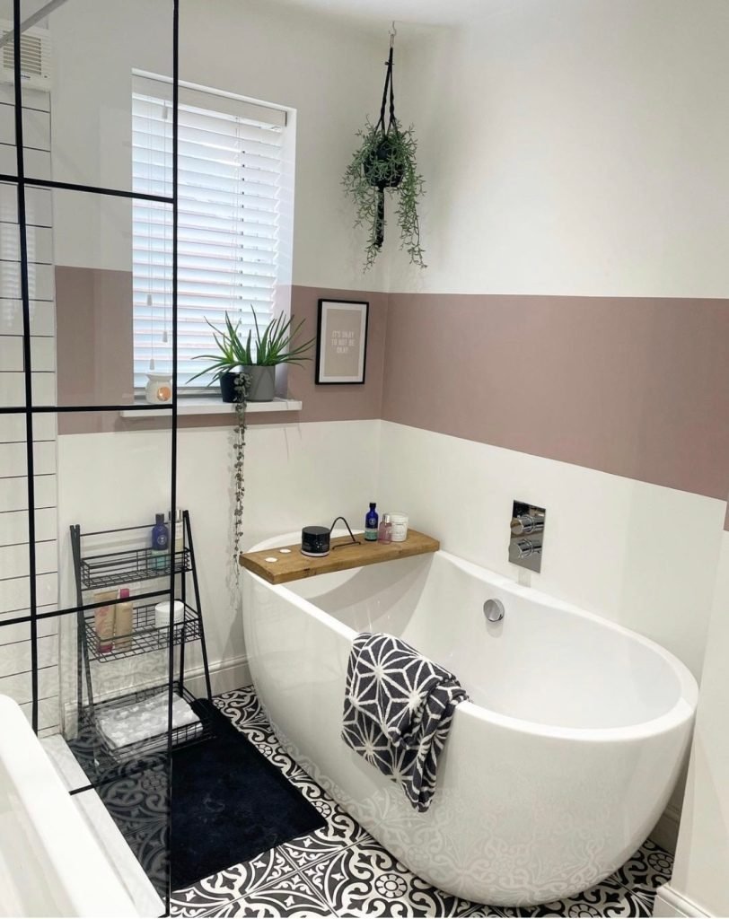 small pink and white bathroom with black window shower pane 