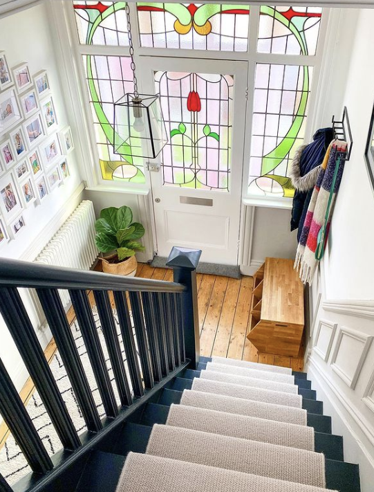 neutral-hallway-ideas-cream-hallway-with-black-banister-and-stain-glass-windows-8609495