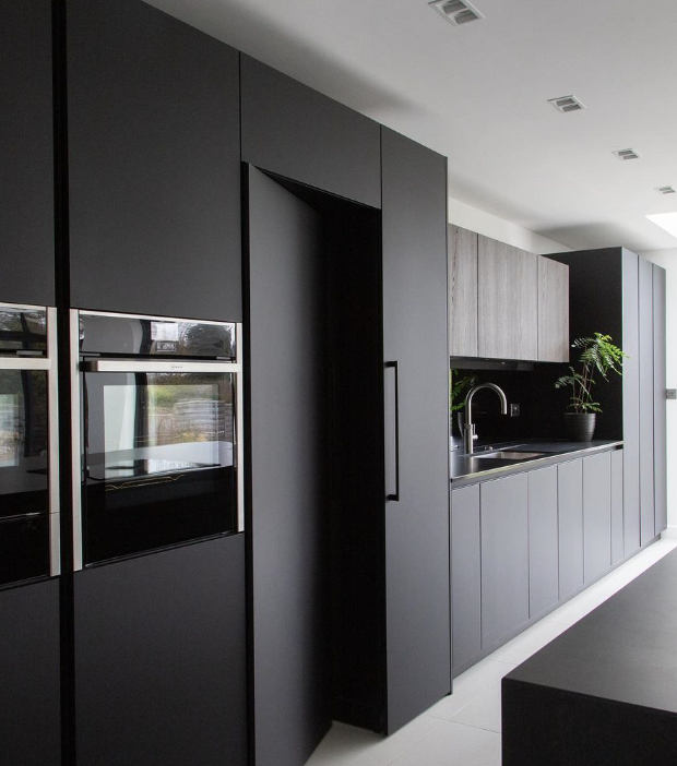 black kitchen with hidden spice cabinet pantry