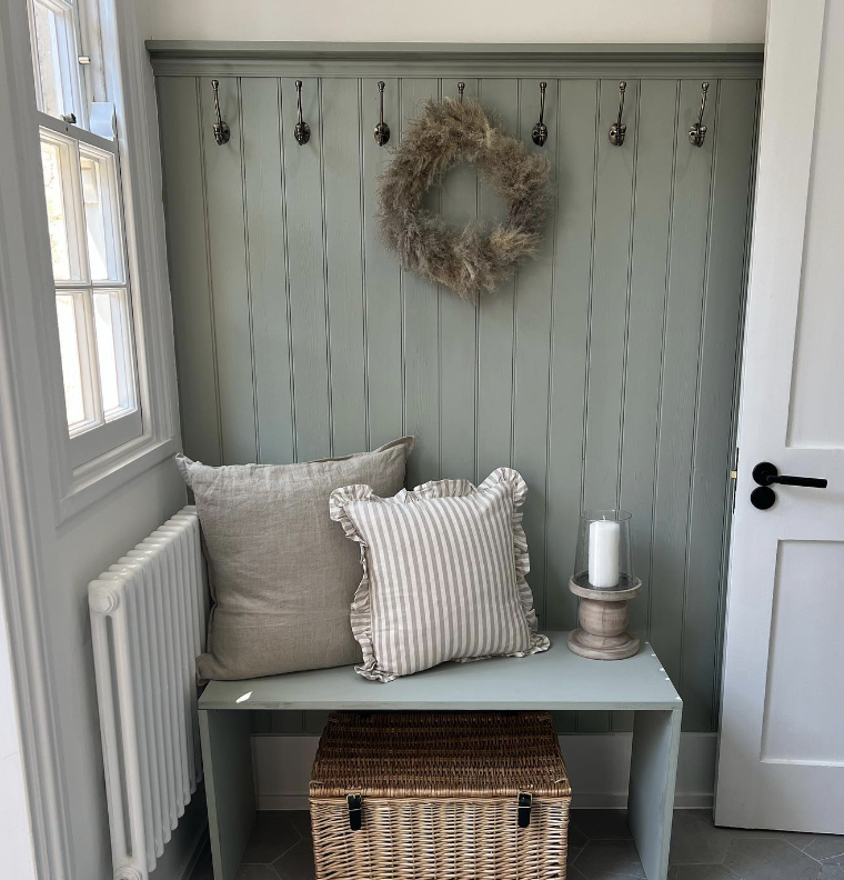 sage green tongue and groove panelling as a coat storage area