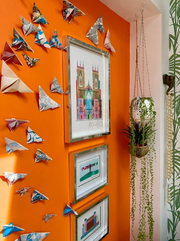 eclectic and colourful gallery wall with hanging plant