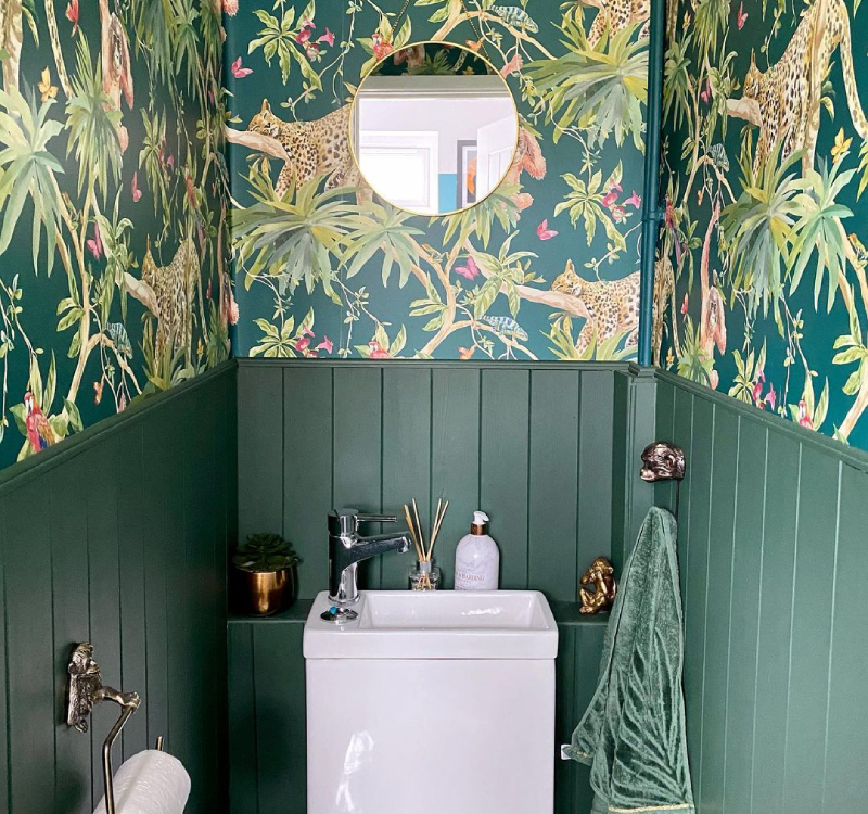 green panelling and safari wallpaper in a downstair toilet