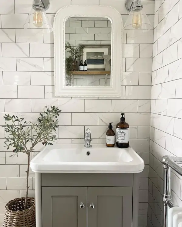 Silver bathroom fixtures in a light grey bathroom