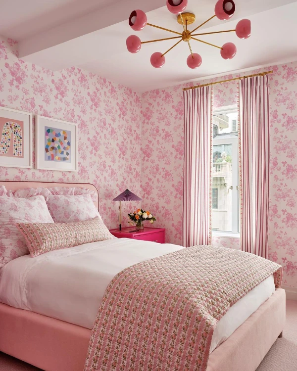 pink bedroom with patterned wallpaper and pink bedding