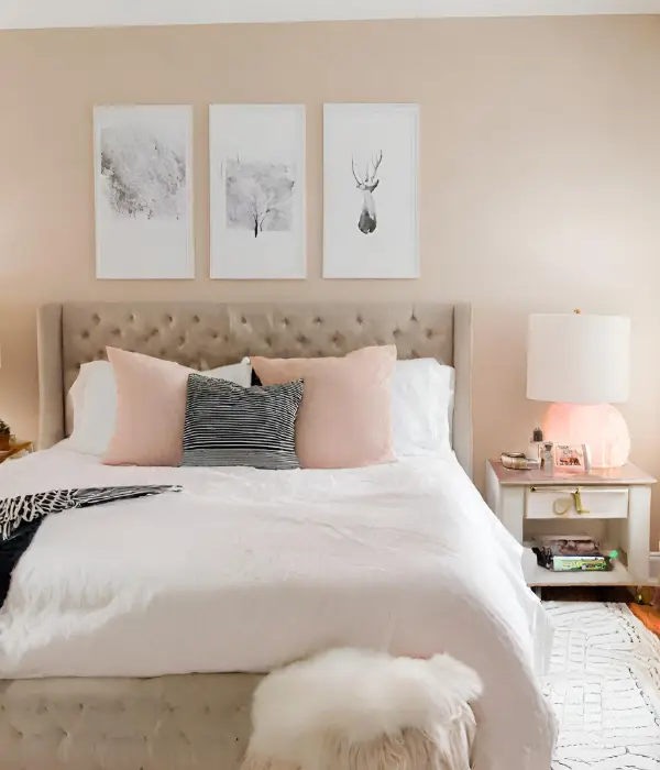 gallery wall above bed in a pink bedroom