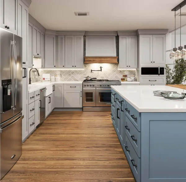 gray kitchen cabinets with a blue kitchen island and wood flooring