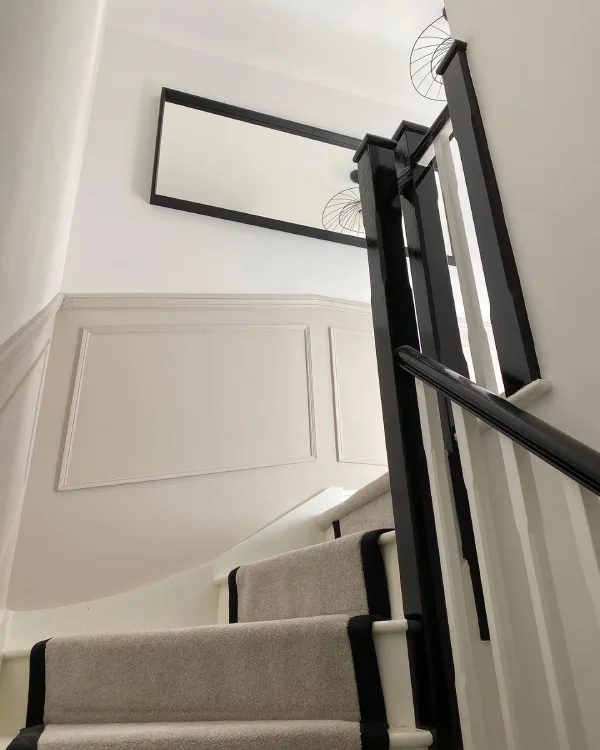 black banister with cream stairs and panelling
