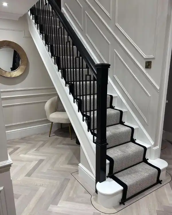 black banister with grey wall panelling