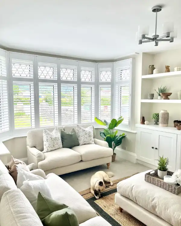 white neutral living room with bay window and shutters