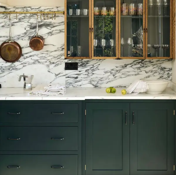 Green and dark wood cabinets against marble splash wall