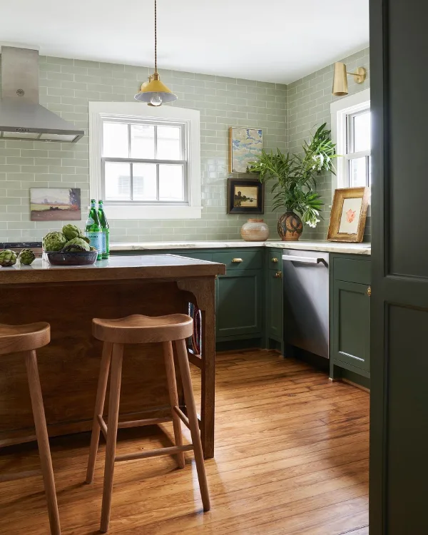 green cabinets and walls with warm wood flooring